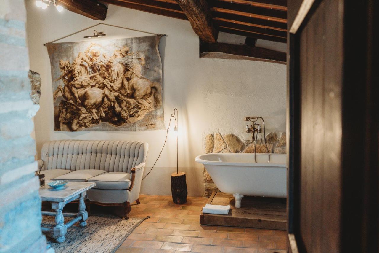 een badkamer met een badkuip en een schilderij aan de muur bij Locanda in Tuscany in Castiglione dʼOrcia