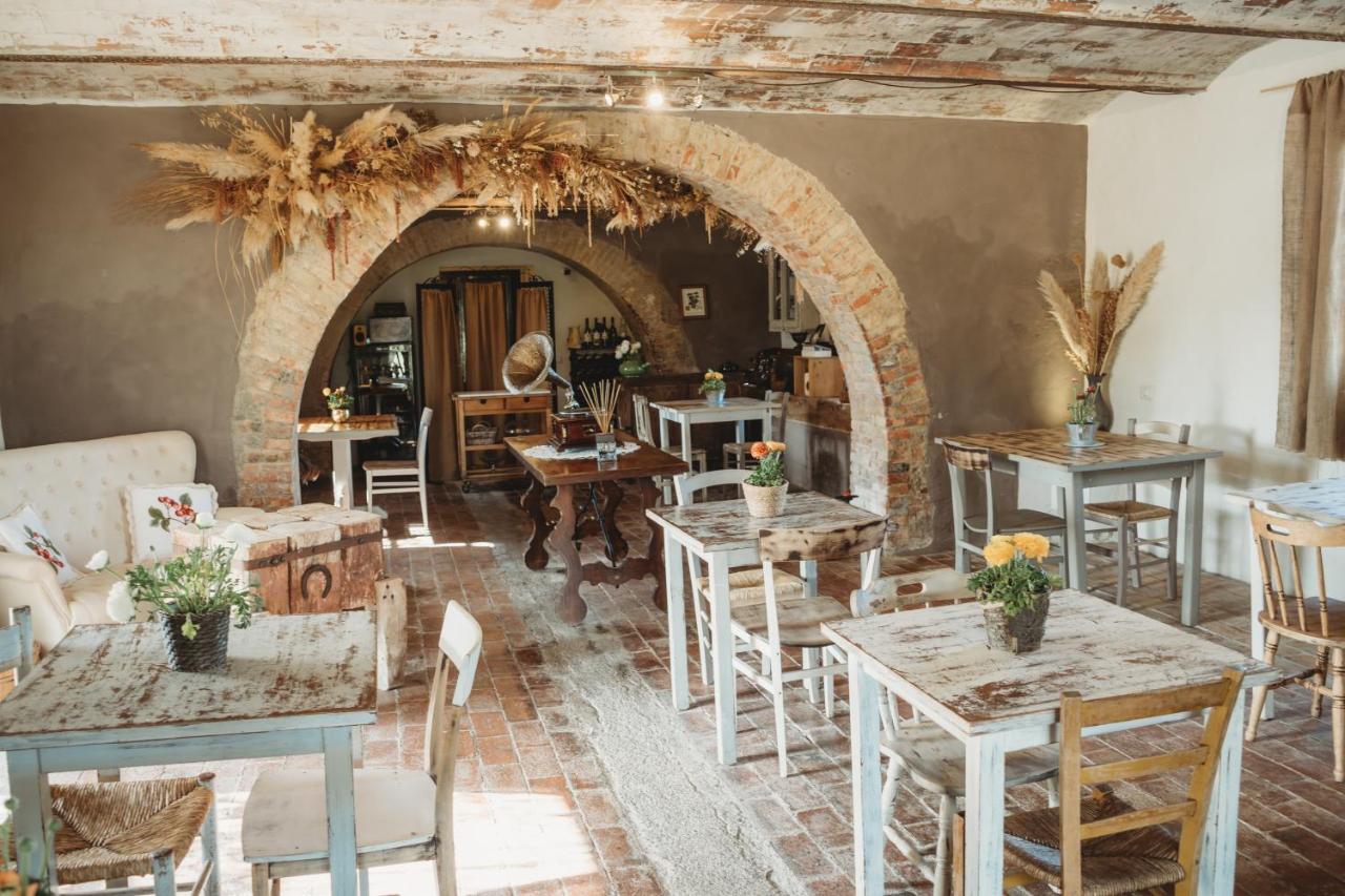 een eetkamer met tafels en stoelen en een boogdoorgang bij Locanda in Tuscany in Castiglione dʼOrcia