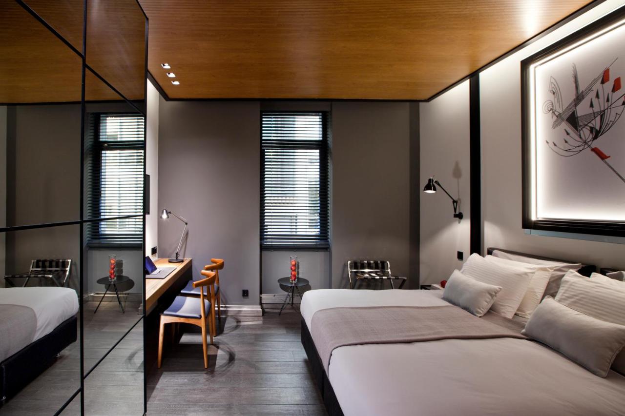 een slaapkamer met twee bedden, een bureau en stoelen bij MET34 Athens in Athene