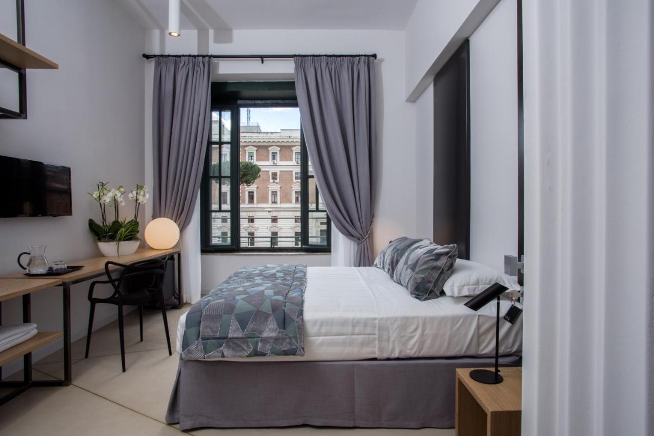 een slaapkamer met een bed, een bureau en een raam bij Viminale View Hotel in Rome