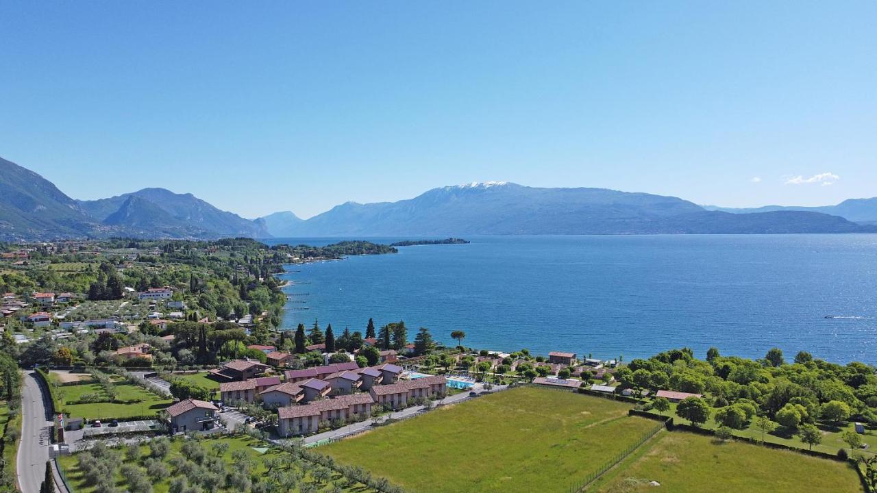 Een luchtfoto van een stad aan een wateroppervlak. bij Onda Blu Resort in Manerba del Garda