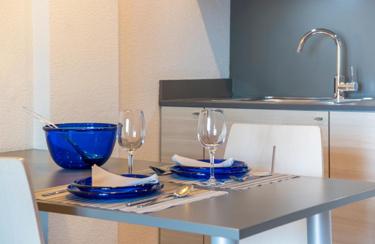 een tafel met twee glazen en borden en een wastafel bij Almirall Apartaments in Lloret de Mar