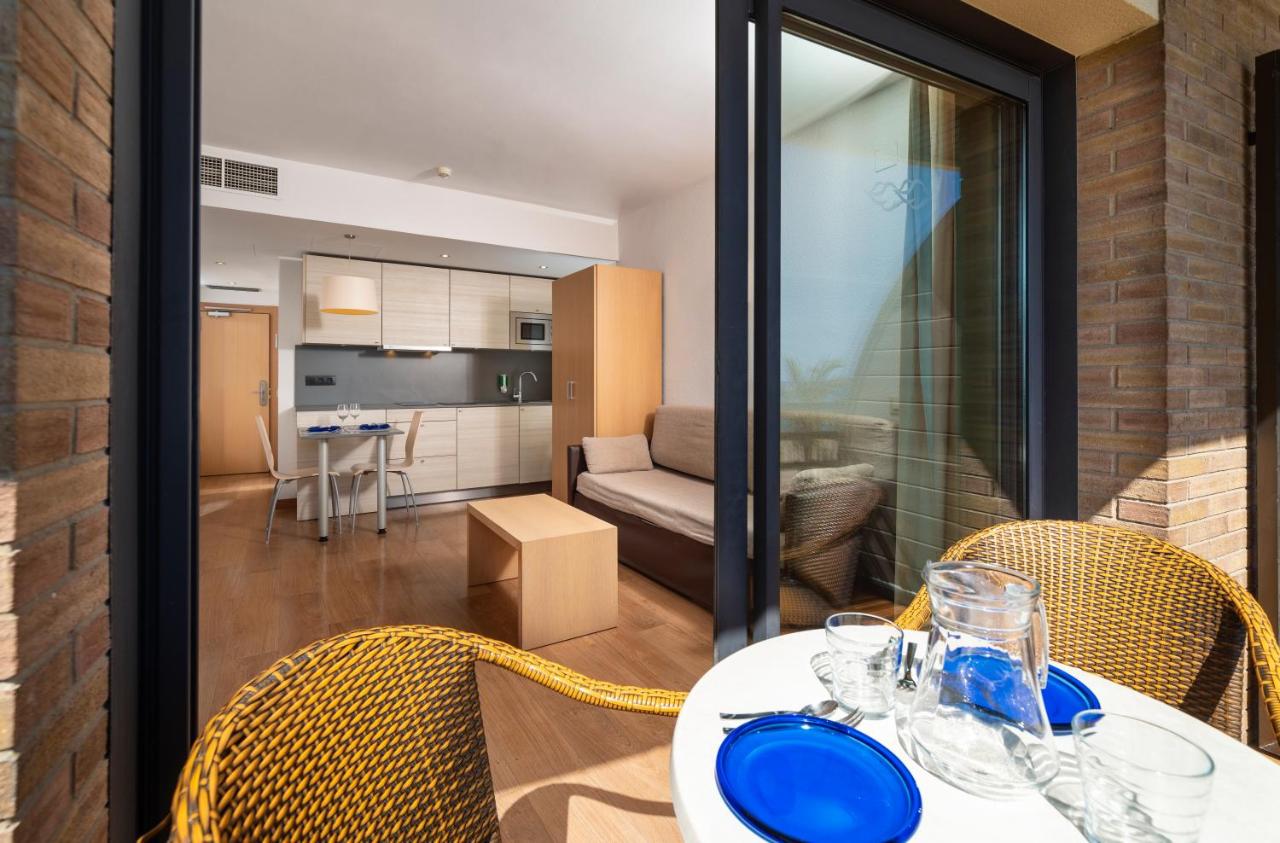 een eettafel met stoelen en een woonkamer bij Almirall Apartaments in Lloret de Mar