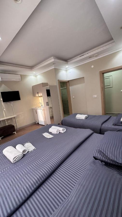 Twee bedden in een grote kamer met handdoeken erop. bij RENOVA OLD CiTY HOTEL in Istanbul