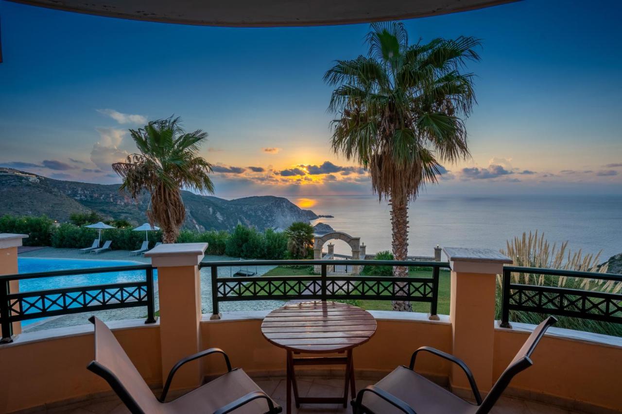 een balkon met een tafel en stoelen en uitzicht op de oceaan bij Niforos Panorama in Vóvikes