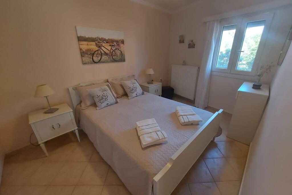 een slaapkamer met een groot bed waarop twee handdoeken liggen bij Apagio apartment in Argostoli