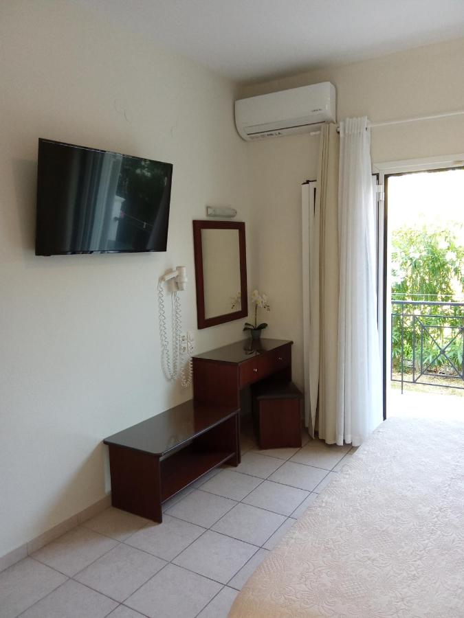 een woonkamer met een tv aan de muur en een spiegel bij Metaxa Apartments in Kavos