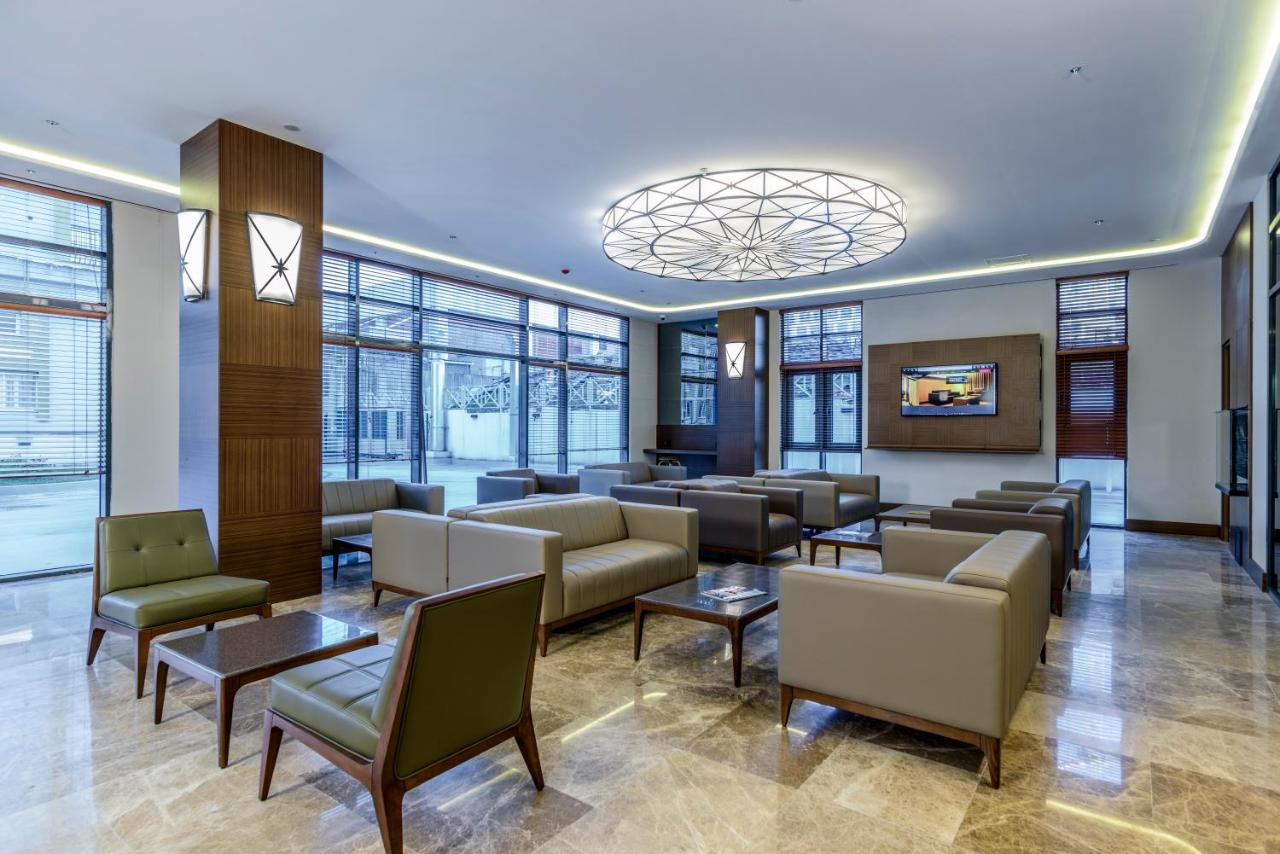 een wachtkamer met banken, tafels en ramen bij Nearport Hotel Sabiha Gokcen Airport in Istanbul