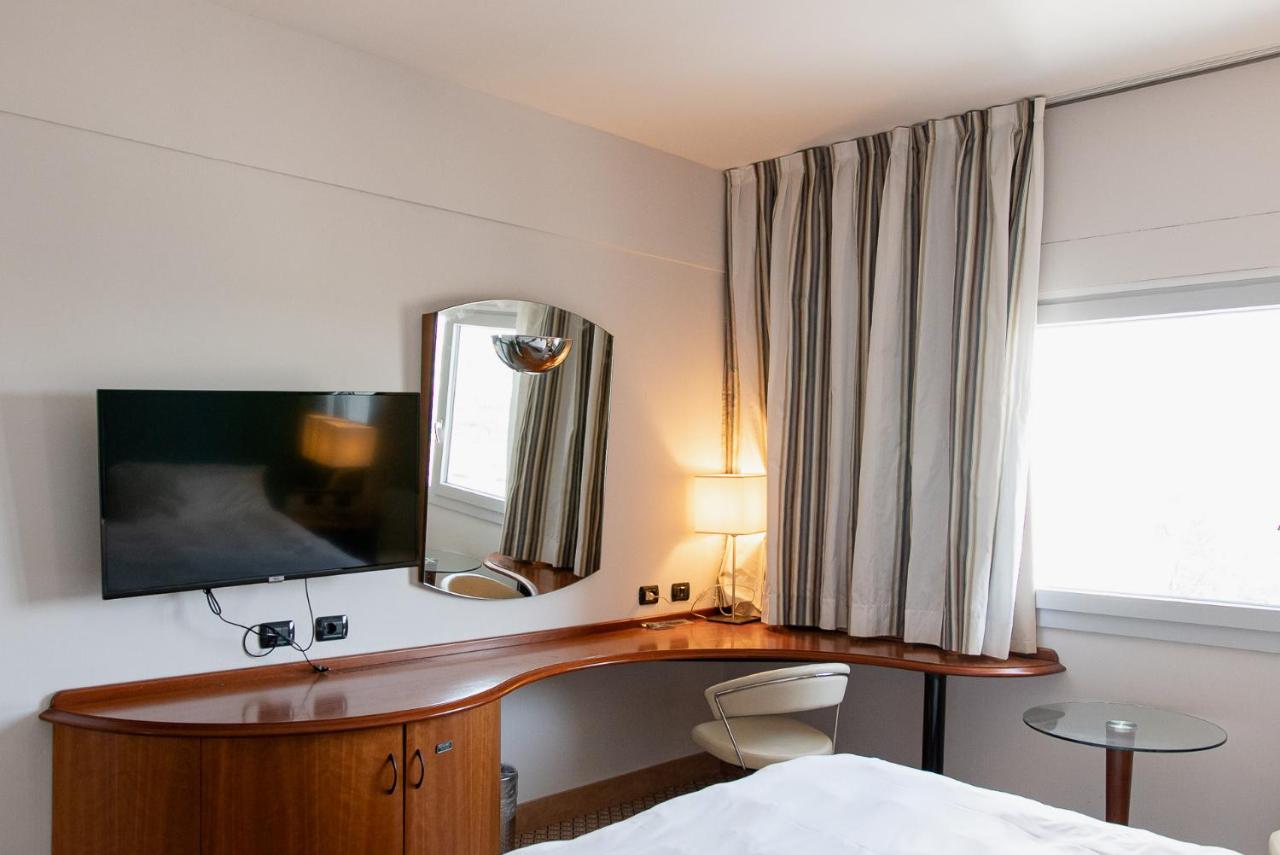 een slaapkamer met een bureau, een spiegel en een bed bij Belstay Milano Assago in Assago