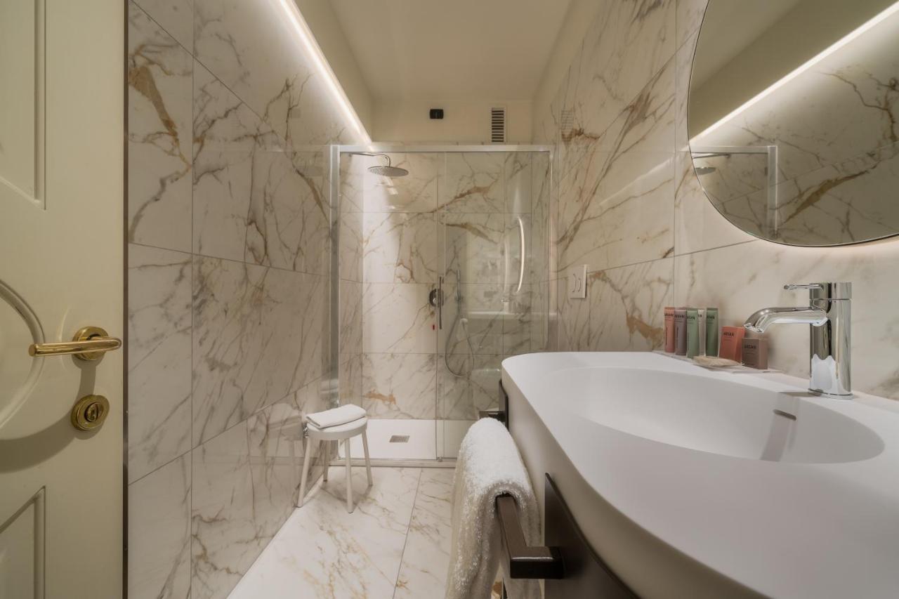 een witte badkamer met een wastafel en een douche bij Hotel Mozart in Milaan