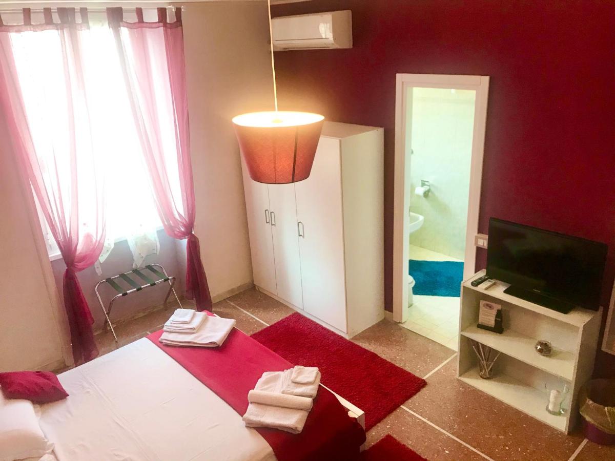 een rode kamer met een bed, een televisie en een badkamer bij A Casa Di Giallo B&B in Rome