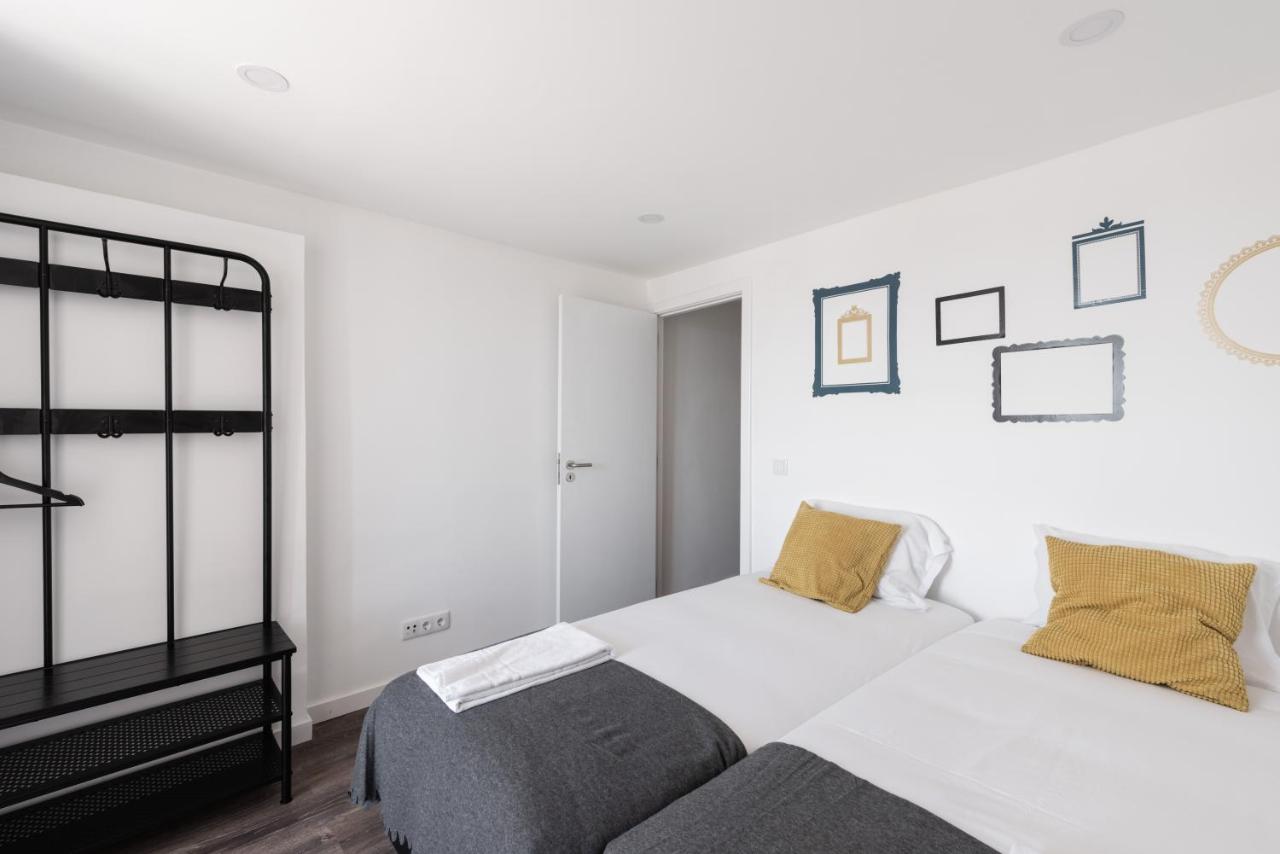een witte slaapkamer met een bed en een raam bij City Stays Cais do Sodre Apartments in Lissabon