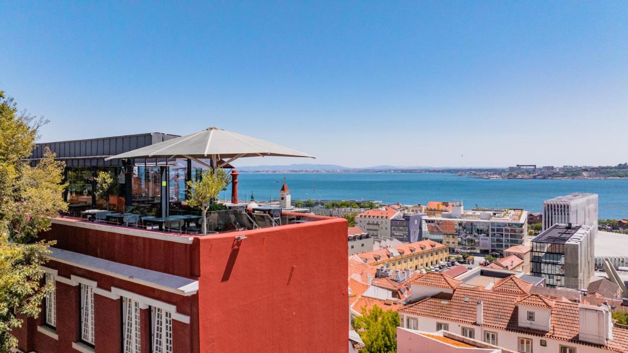 een dakterrascafé met een parasol bovenop een gebouw bij Monte Belvedere Hotel by Shiadu in Lissabon