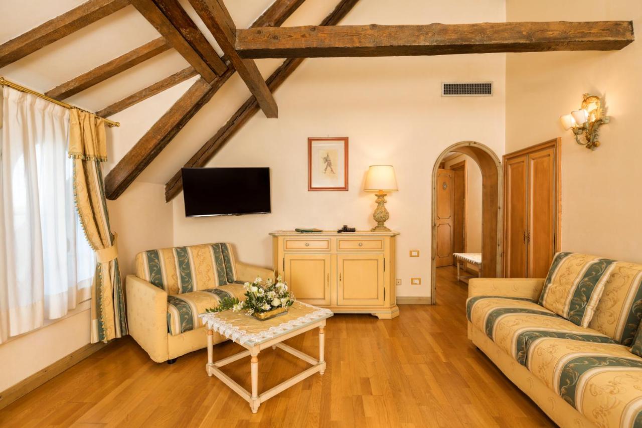een woonkamer met twee banken en een tv bij Hotel Villa Laguna in Venetië-Lido