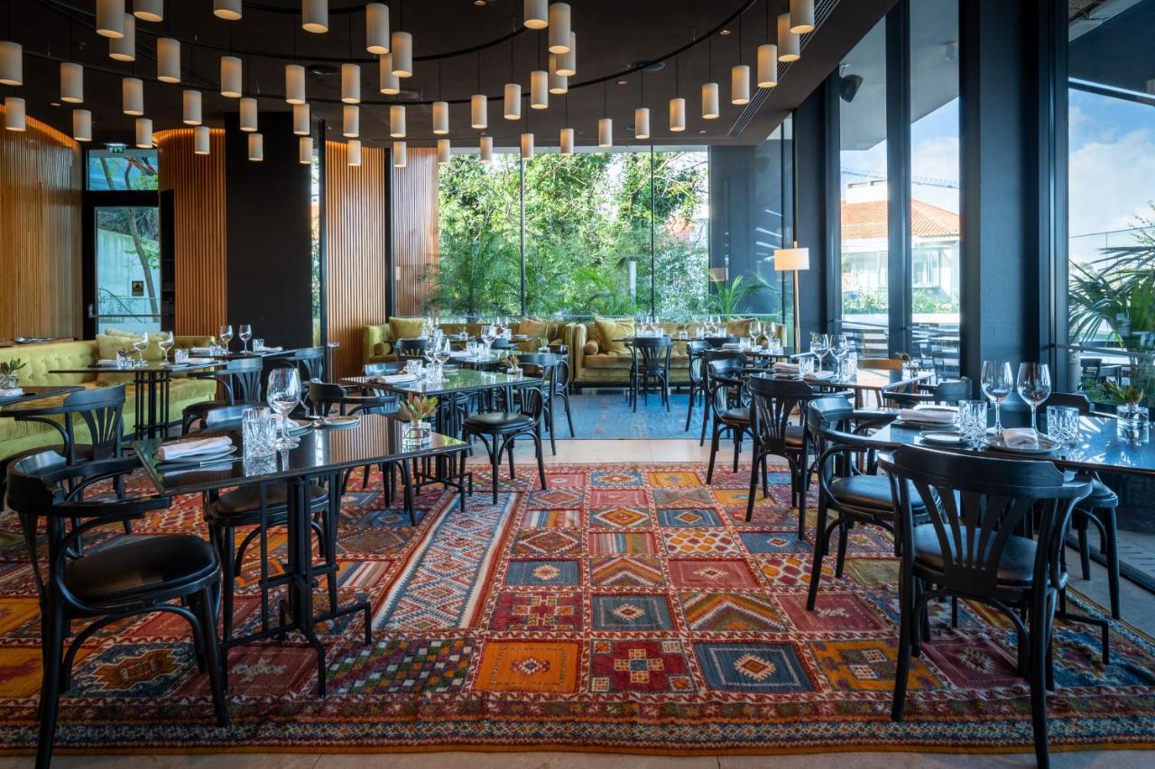 een restaurant met tafels en stoelen op een tapijt bij Memmo Príncipe Real, a Member of Design Hotels in Lissabon +45 fo