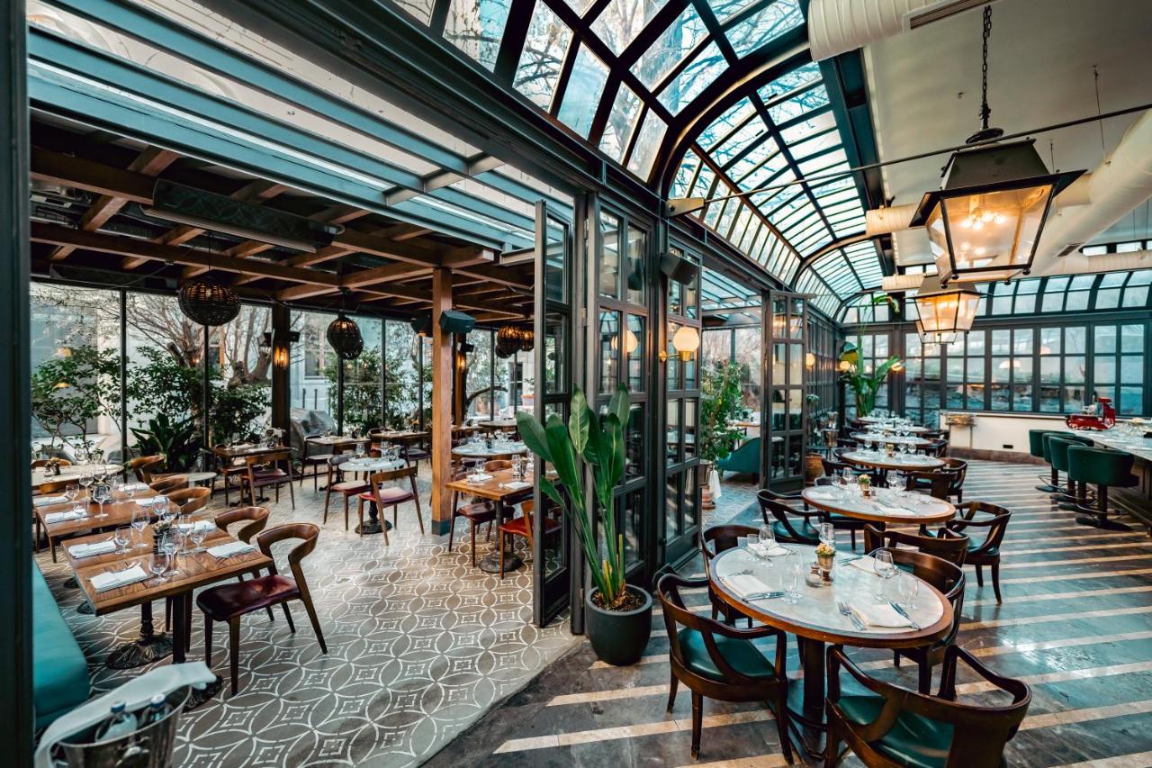 een restaurant met tafels en stoelen en een glazen plafond bij Soho House Istanbul in Istanbul
