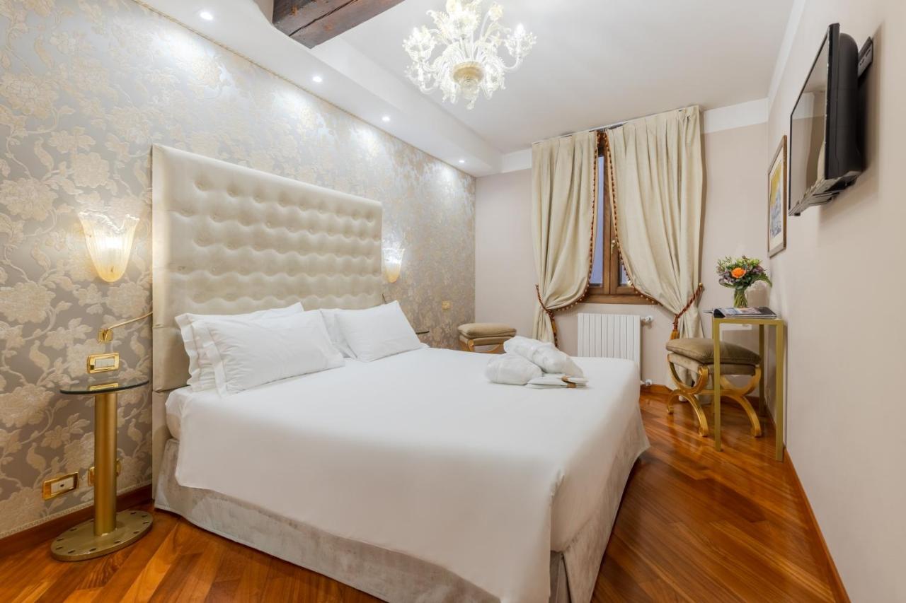 een slaapkamer met een groot wit bed in een kamer bij Cà dell'arte Suite in Venetië