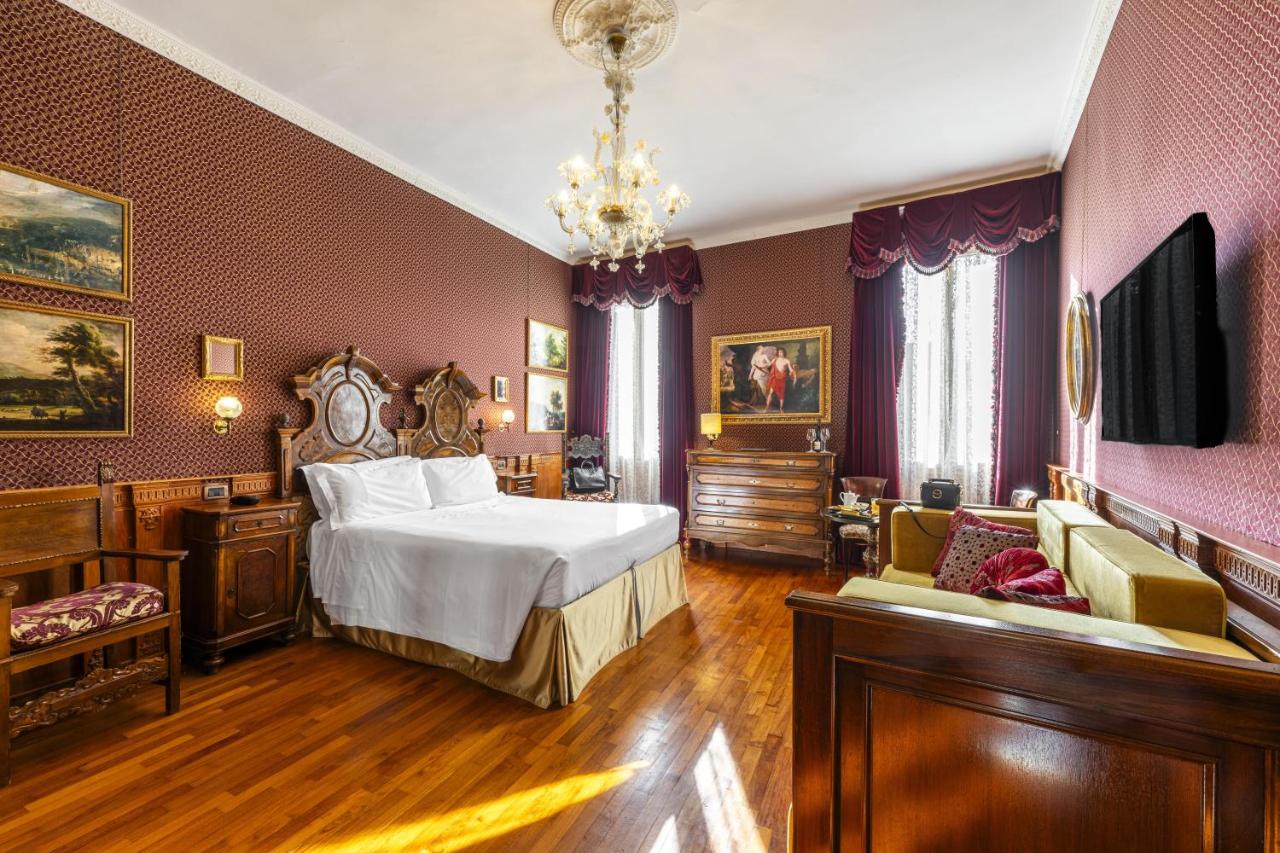 een slaapkamer met een bed en een kroonluchter bij Hotel Casa Nicolò Priuli in Venetië