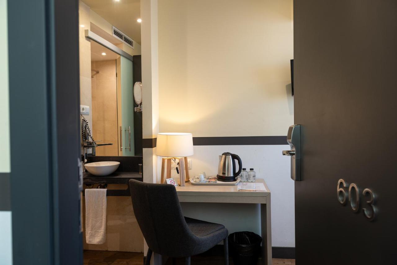 een bureau met een lamp en een stoel in een kamer bij May Ramblas Hotel in Barcelona