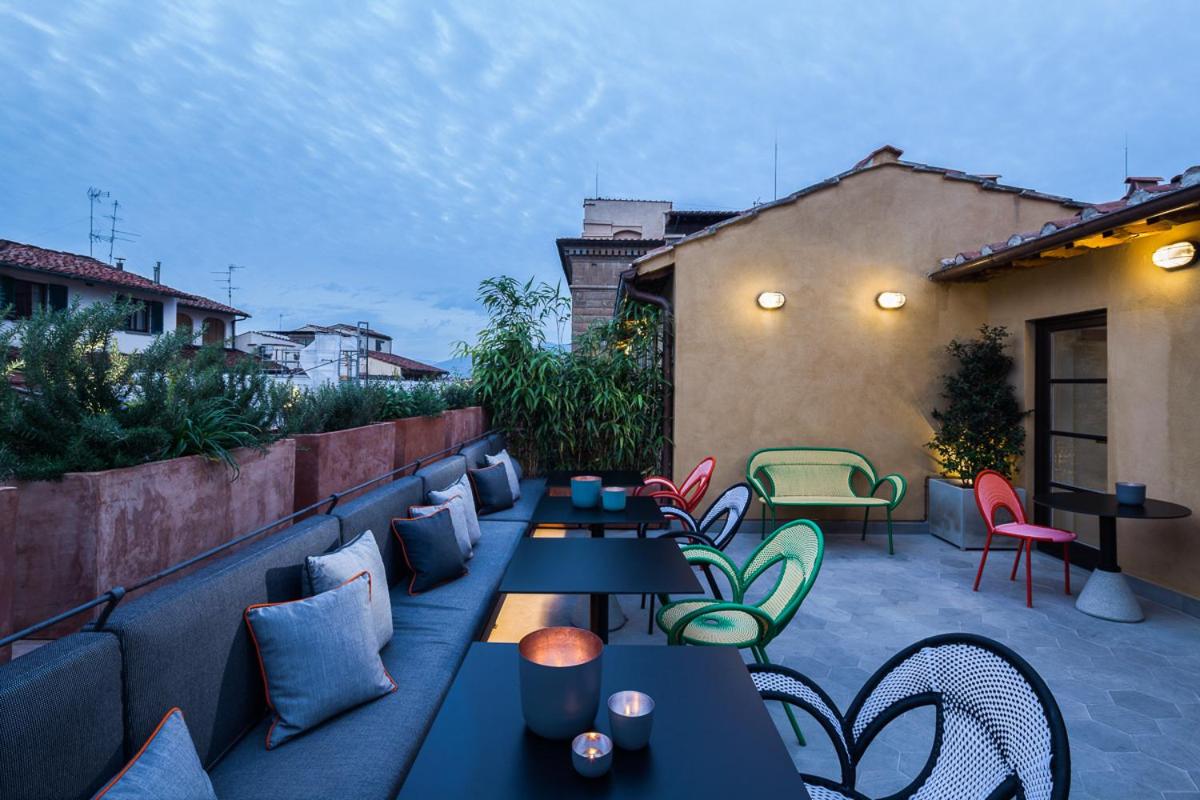 een terras met tafels en stoelen op een dakterras bij Hotel Milu Florence in Florence