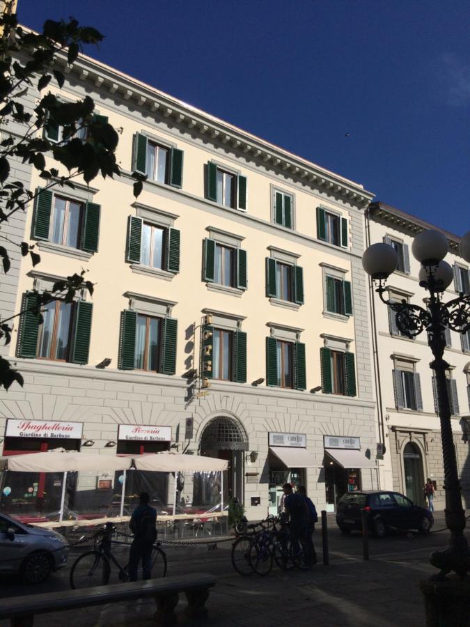 een groot wit gebouw met groene luiken voor de ramen bij Hotel Caravaggio in Florence
