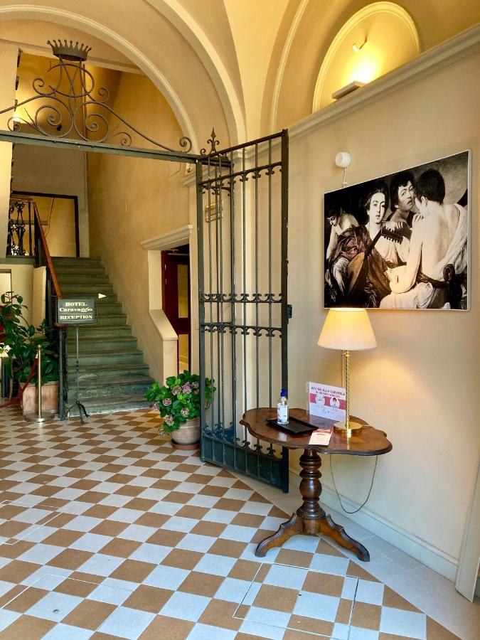 een gang met een tafel en een schilderij aan de muur bij Hotel Caravaggio in Florence