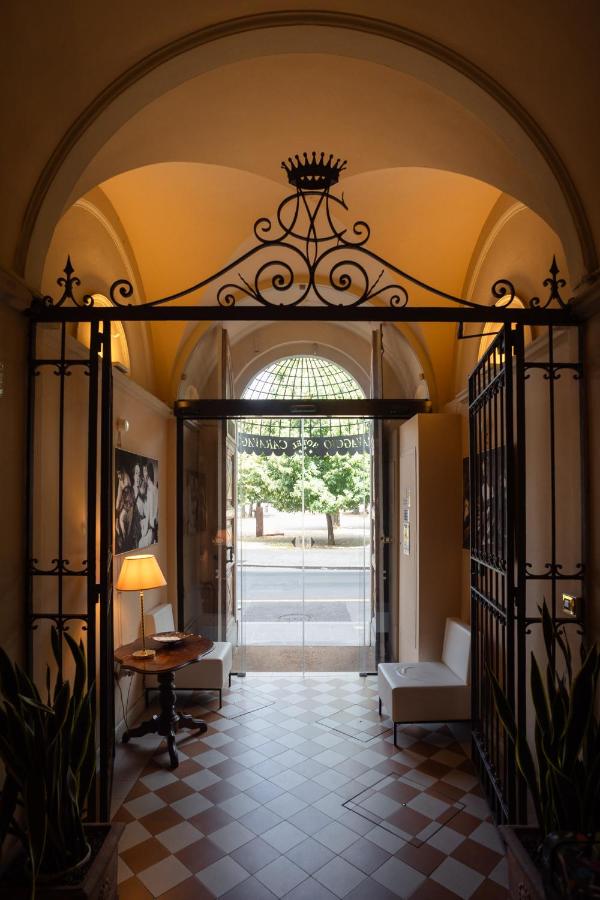een entree met een boog, een tafel en stoelen bij Hotel Caravaggio in Florence