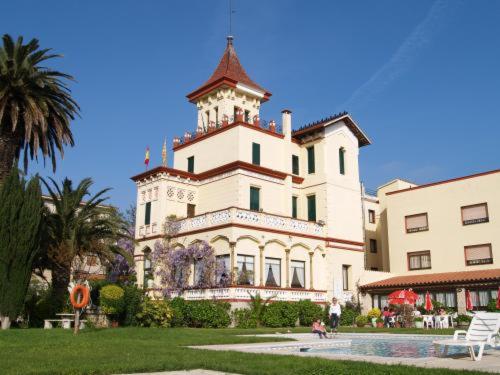 een groot gebouw met een toren erop bij Hotel Hostal del Sol in Sant Feliu de Guixols