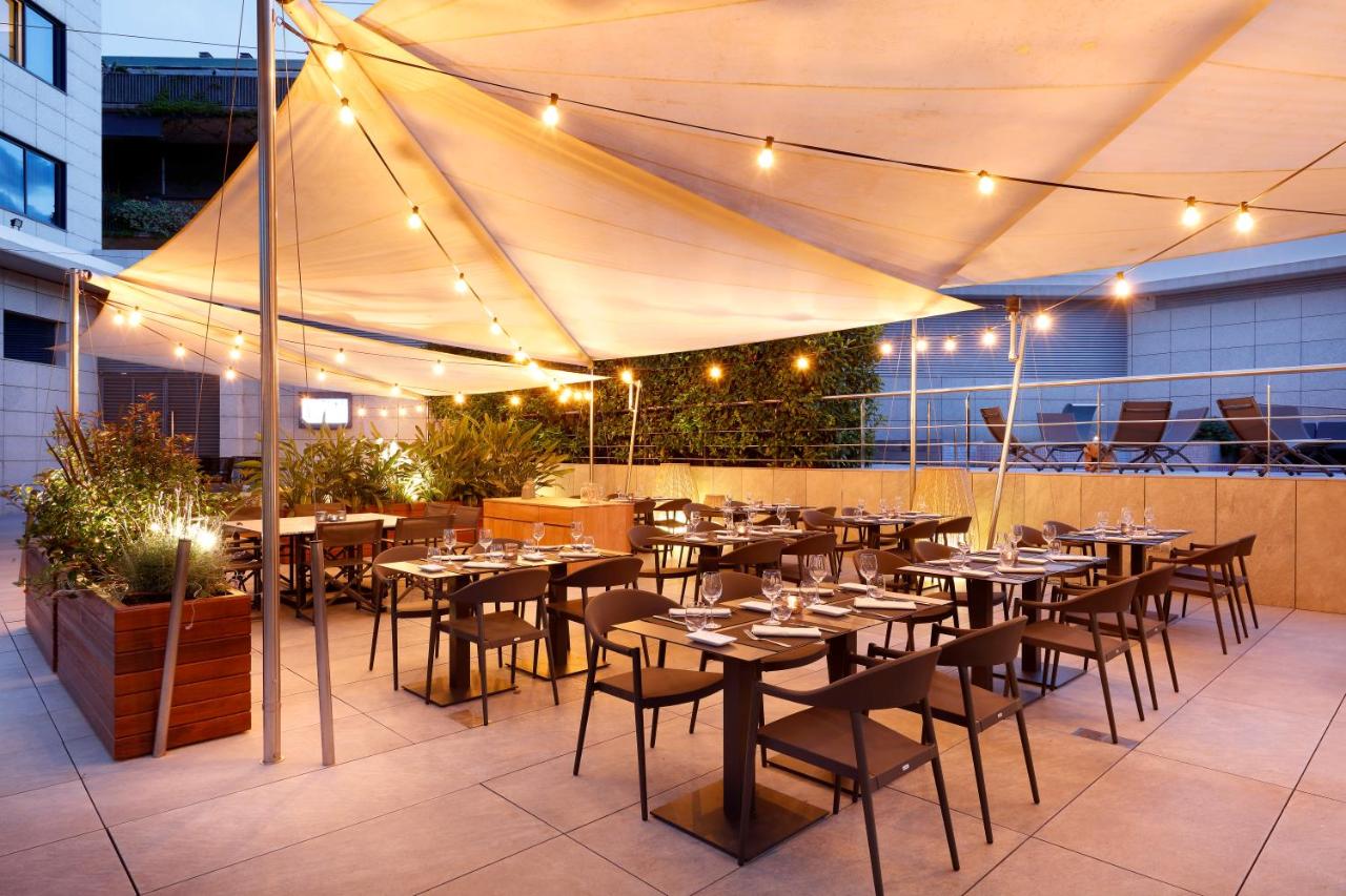 een restaurant met tafels en stoelen onder een tent bij Hotel SB Icaria in Barcelona