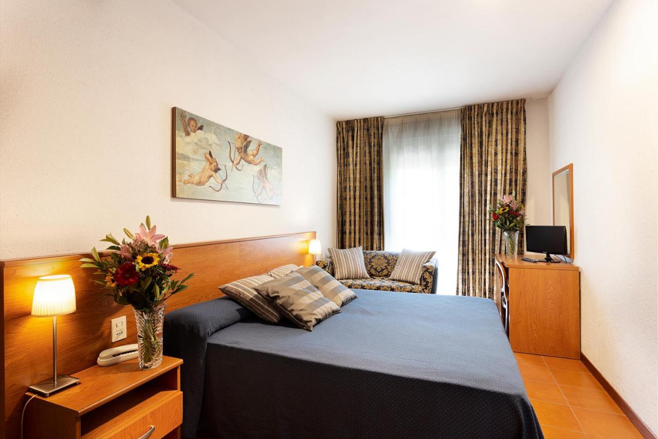 een hotelkamer met een bed en een bank bij Hotel Corolle in Florence