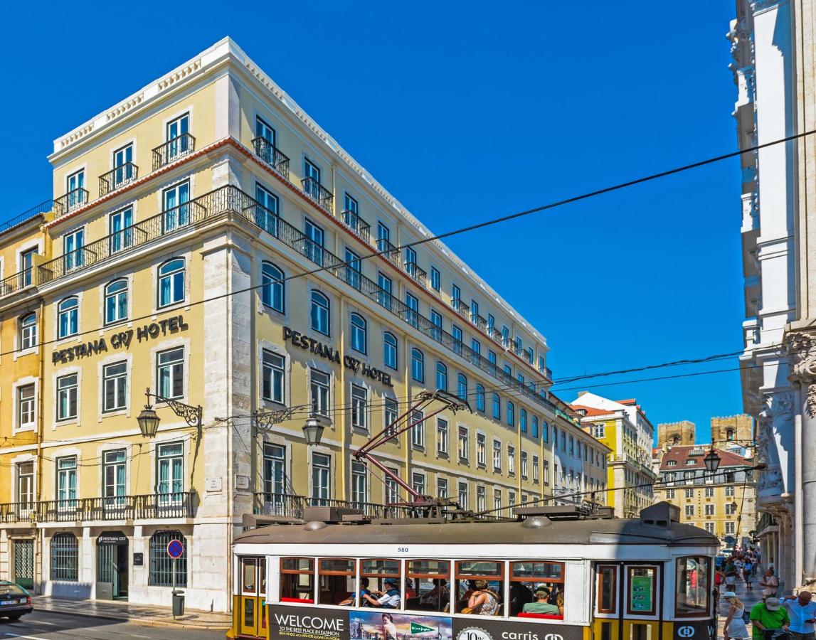 een tram voor een groot gebouw bij Pestana CR7 Lisboa in Lissabon