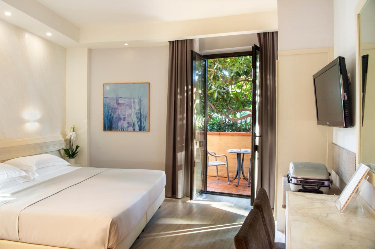 een slaapkamer met een bed en een balkon met een tafel bij Hotel Grifone Firenze - Meetings & Spa in Florence