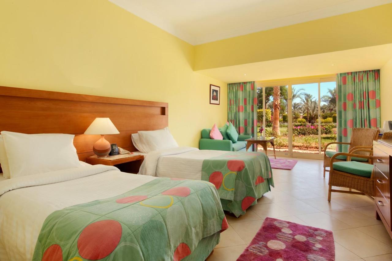 een hotelkamer met twee bedden en een stoel bij TIME Coral Nuweiba Resort in Nuweiba