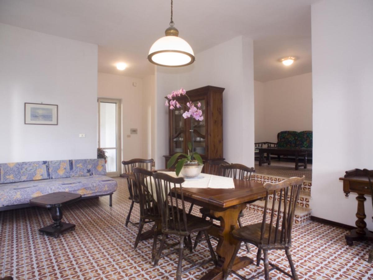 een woonkamer met een tafel en een blauwe bank bij Homeholiday Giulivo in Baia Domizia
