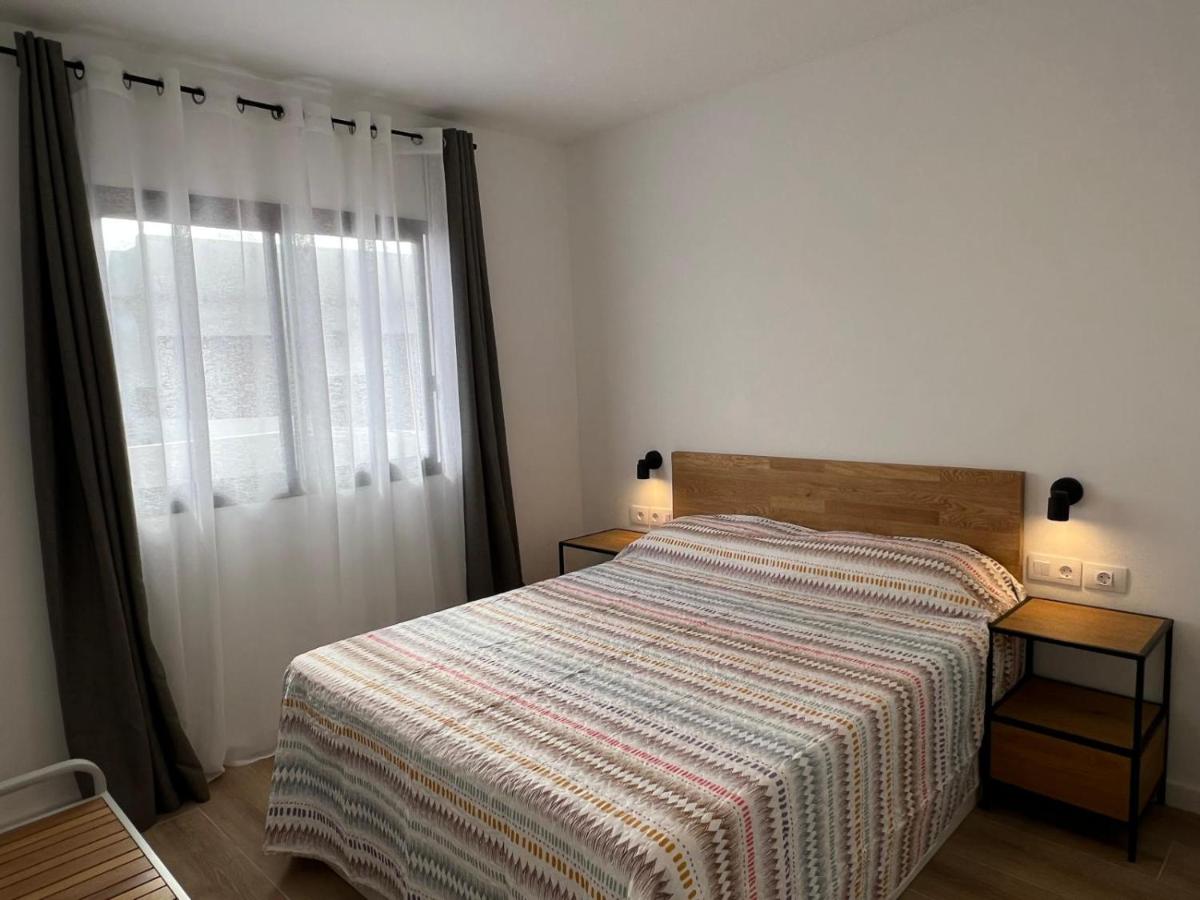 een slaapkamer met een bed met een gestreepte deken en een raam bij Dunasol 311 in Corralejo