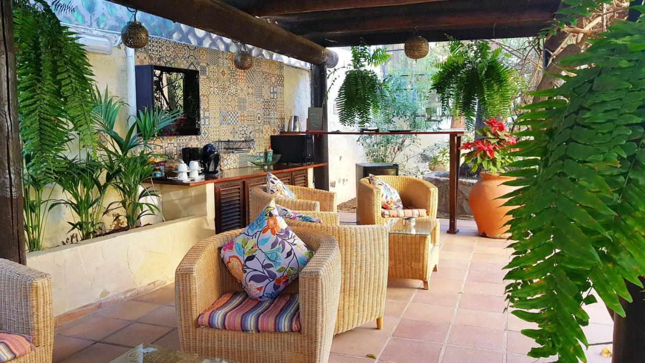 een terras buiten met rieten stoelen en een tafel bij Alsol Nogal- Adults Only in Playa del Inglés