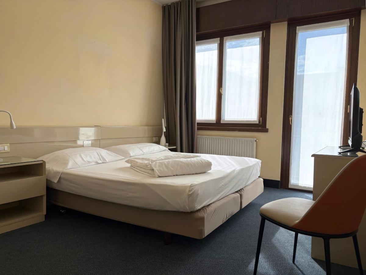 een hotelkamer met een bed en een stoel bij Hotel Bristol in Riva del Garda