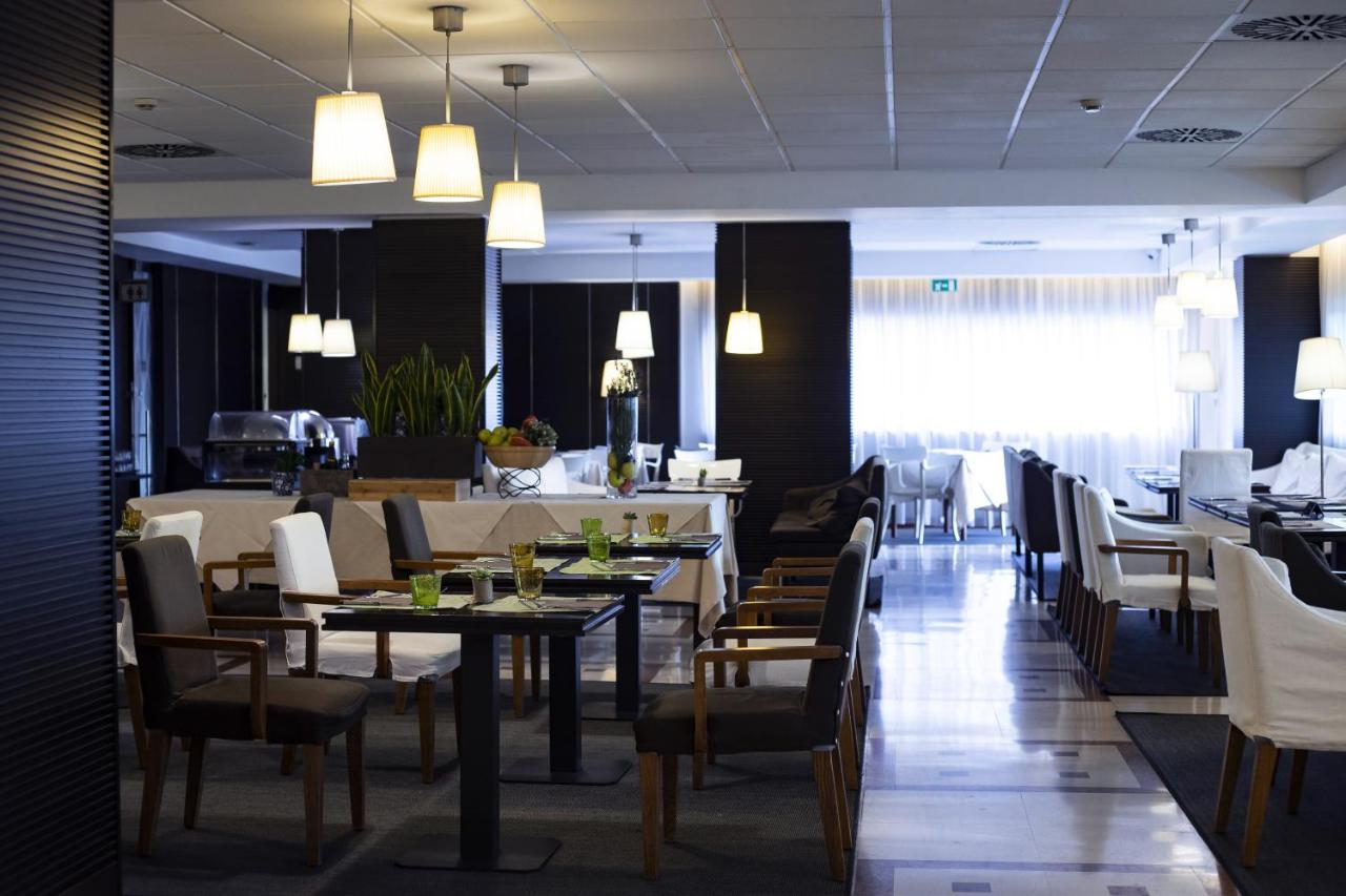 een eetzaal met tafels en stoelen en een restaurant bij BV Hotel Oly in Rome