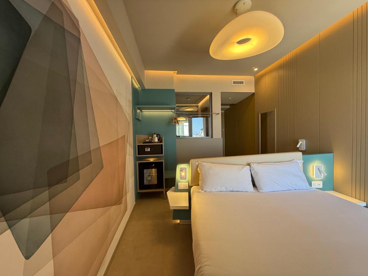 een slaapkamer met een wit bed en een bank bij President Hotel Palermo in Palermo