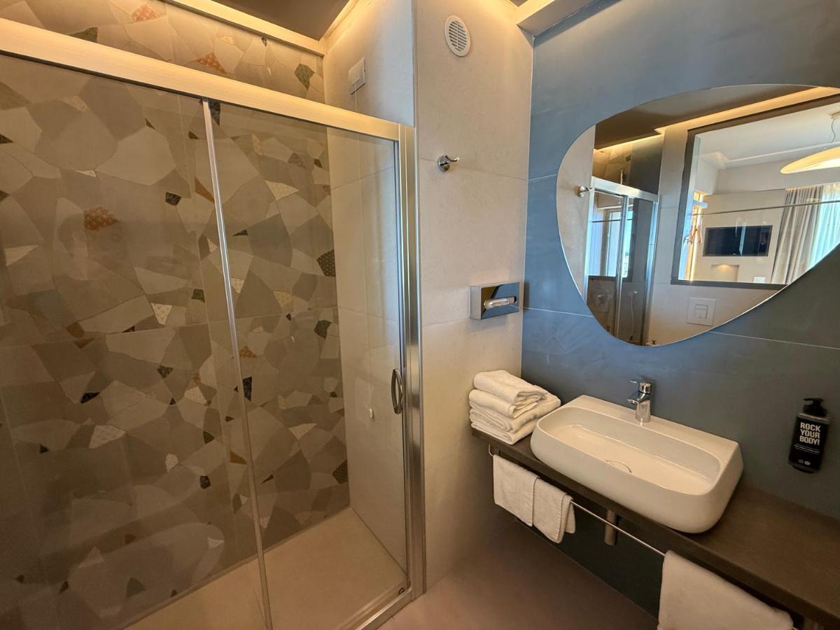 een badkamer met een douche, een wastafel en een spiegel bij President Hotel Palermo in Palermo