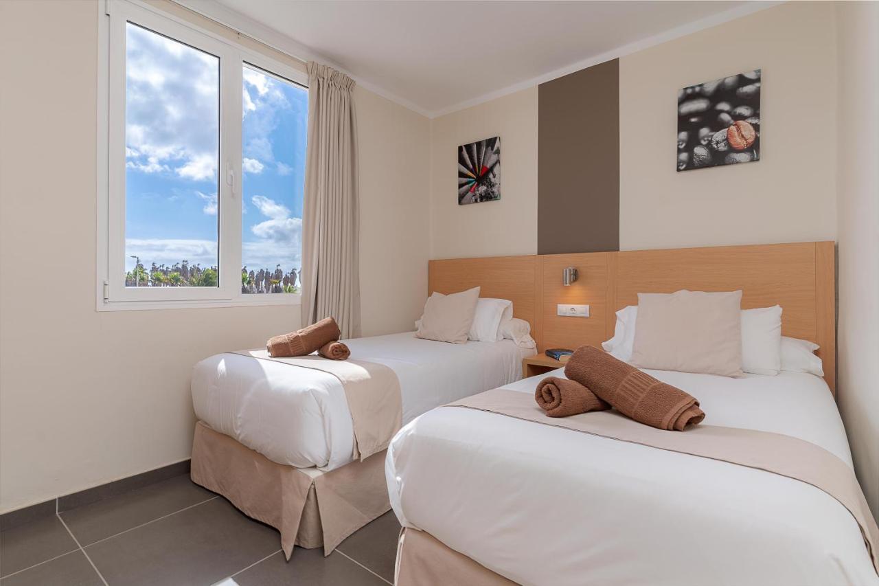 een hotelkamer met twee bedden en een raam bij Hotel Siroco by SeaSense- Adults Only 18 in Costa Teguise
