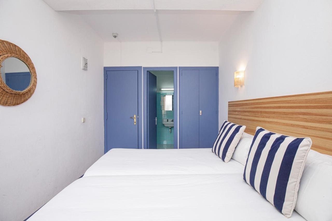 een slaapkamer met een groot bed en blauwe deuren bij Hotel Casa Mas in Lloret de Mar