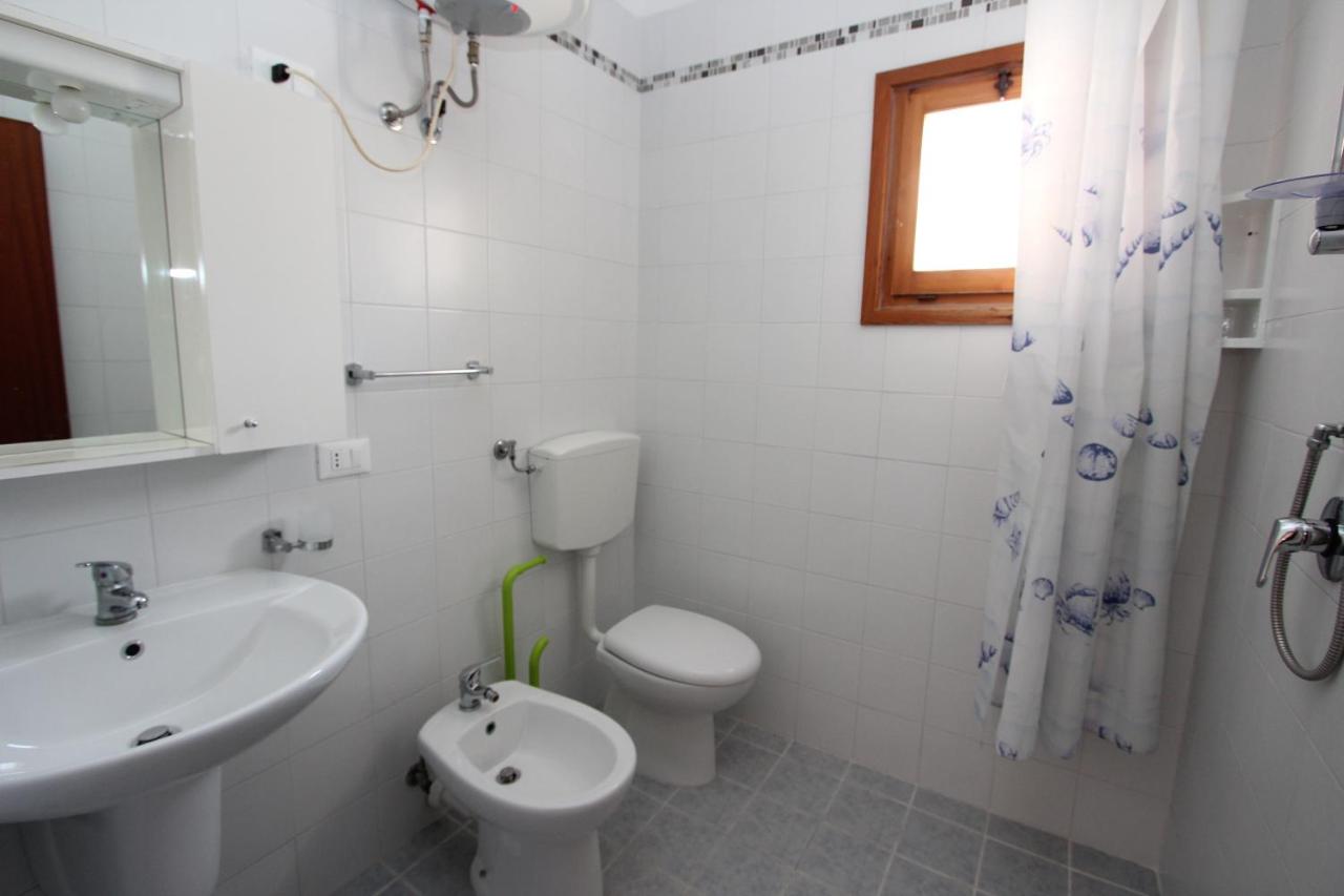 een witte badkamer met een toilet en een wastafel bij San Michele in Bibione