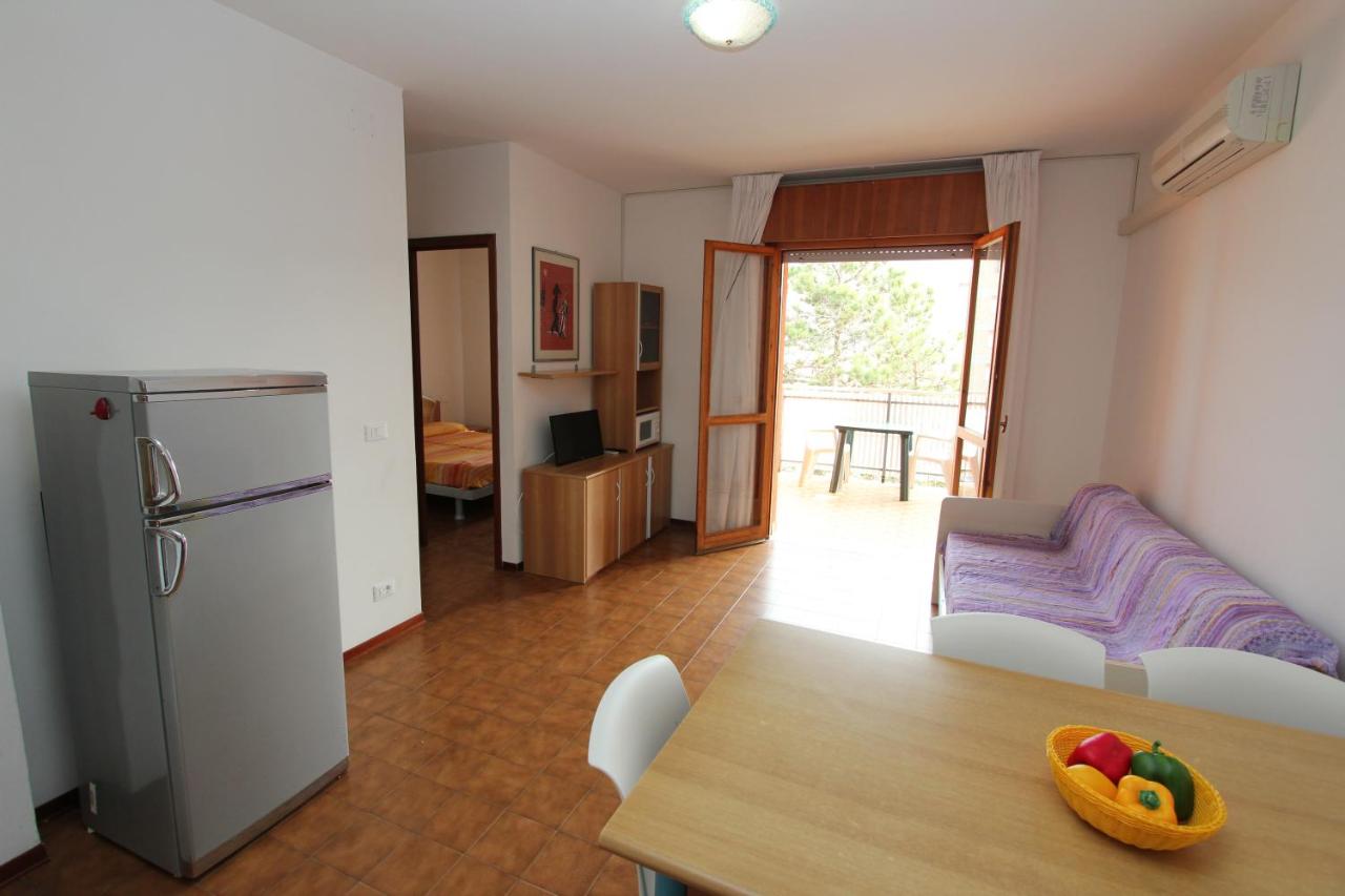een keuken en woonkamer met een tafel en een koelkast bij San Michele in Bibione +13 foto's