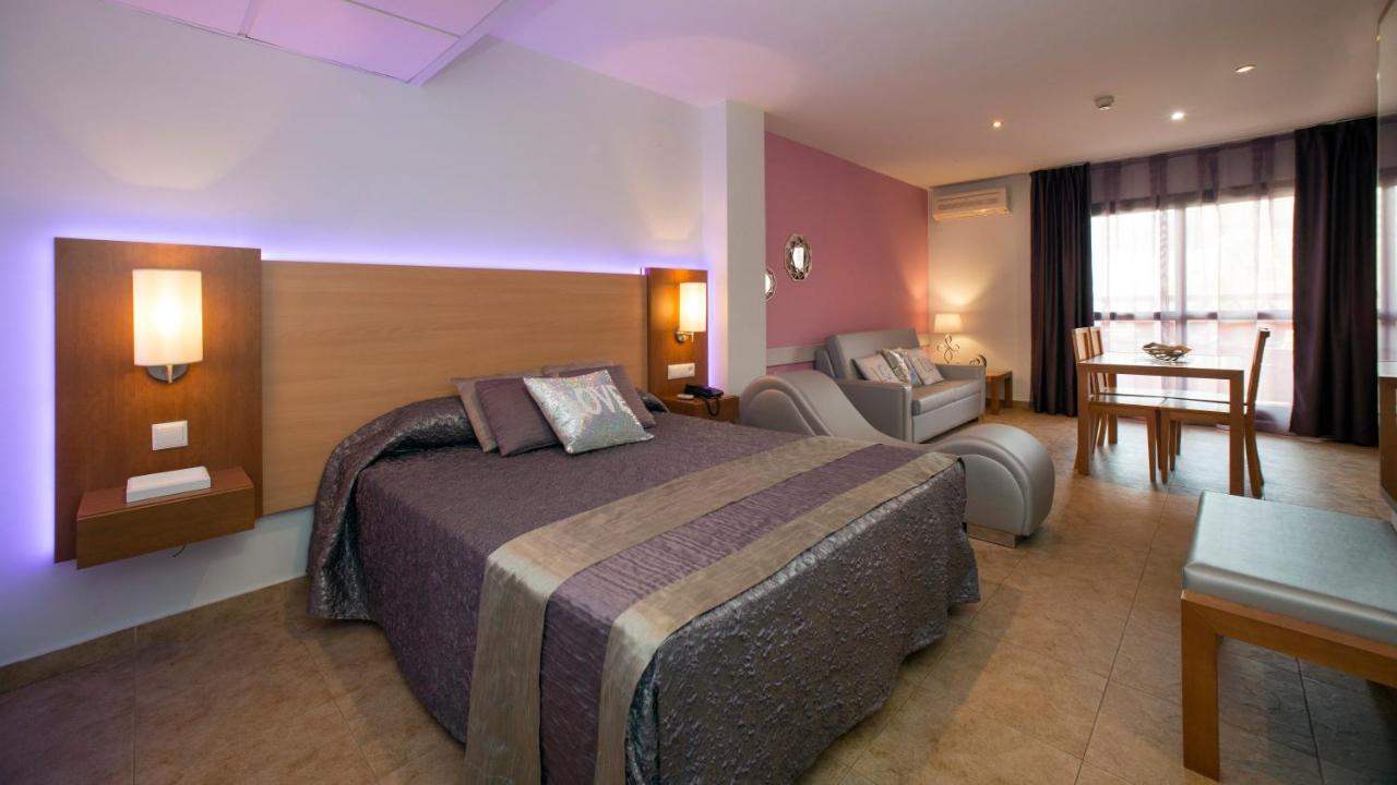 een hotelkamer met een groot bed en een stoel bij Leo Punta Umbría - Adults Only in Punta Umbría