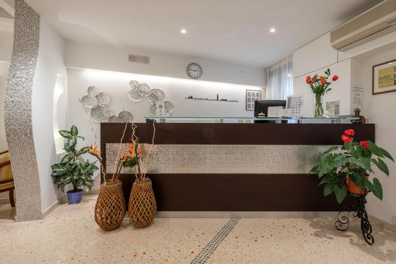 een lobby met een receptiebalie en vazen met planten bij Hotel Antigo Trovatore in Venetië