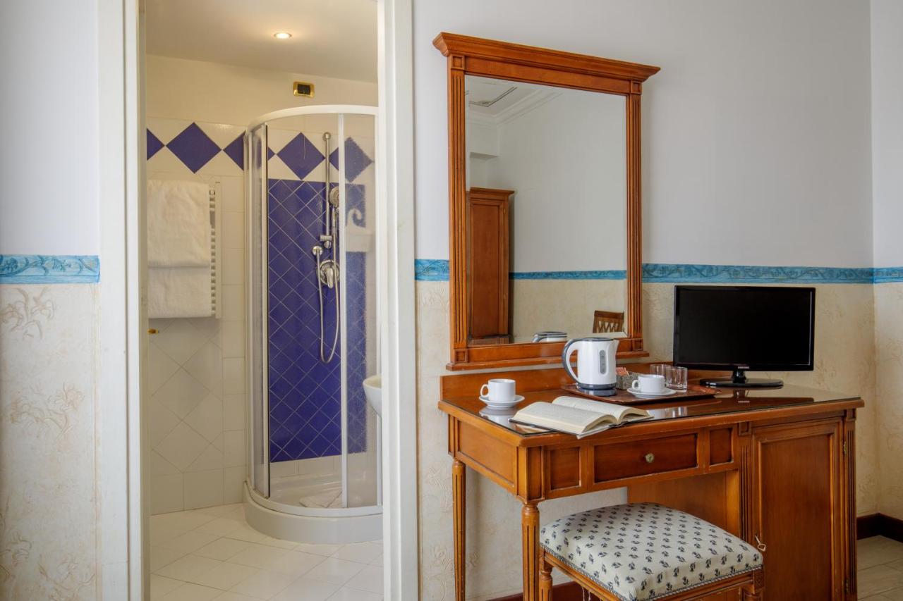 een badkamer met een bureau met een televisie en een douche bij Hotel Alessandrino in Rome
