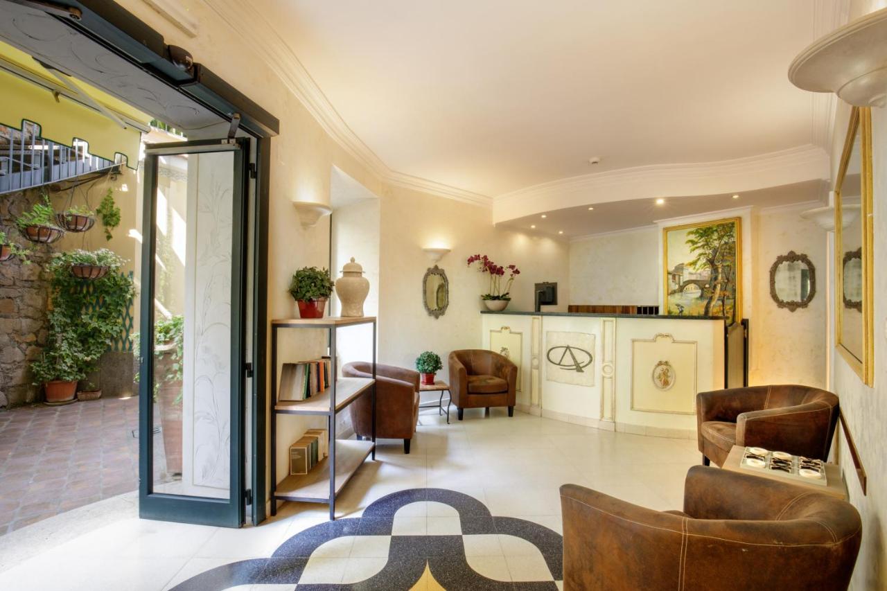 een woonkamer met stoelen en een tafel en een keuken bij Hotel Alessandrino in Rome