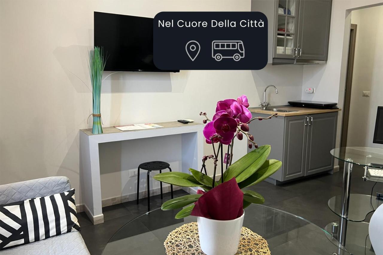 een woonkamer met een vaas met paarse bloemen op een tafel bij Floor 6 Boutique Rooms by DOT Suites in Rome