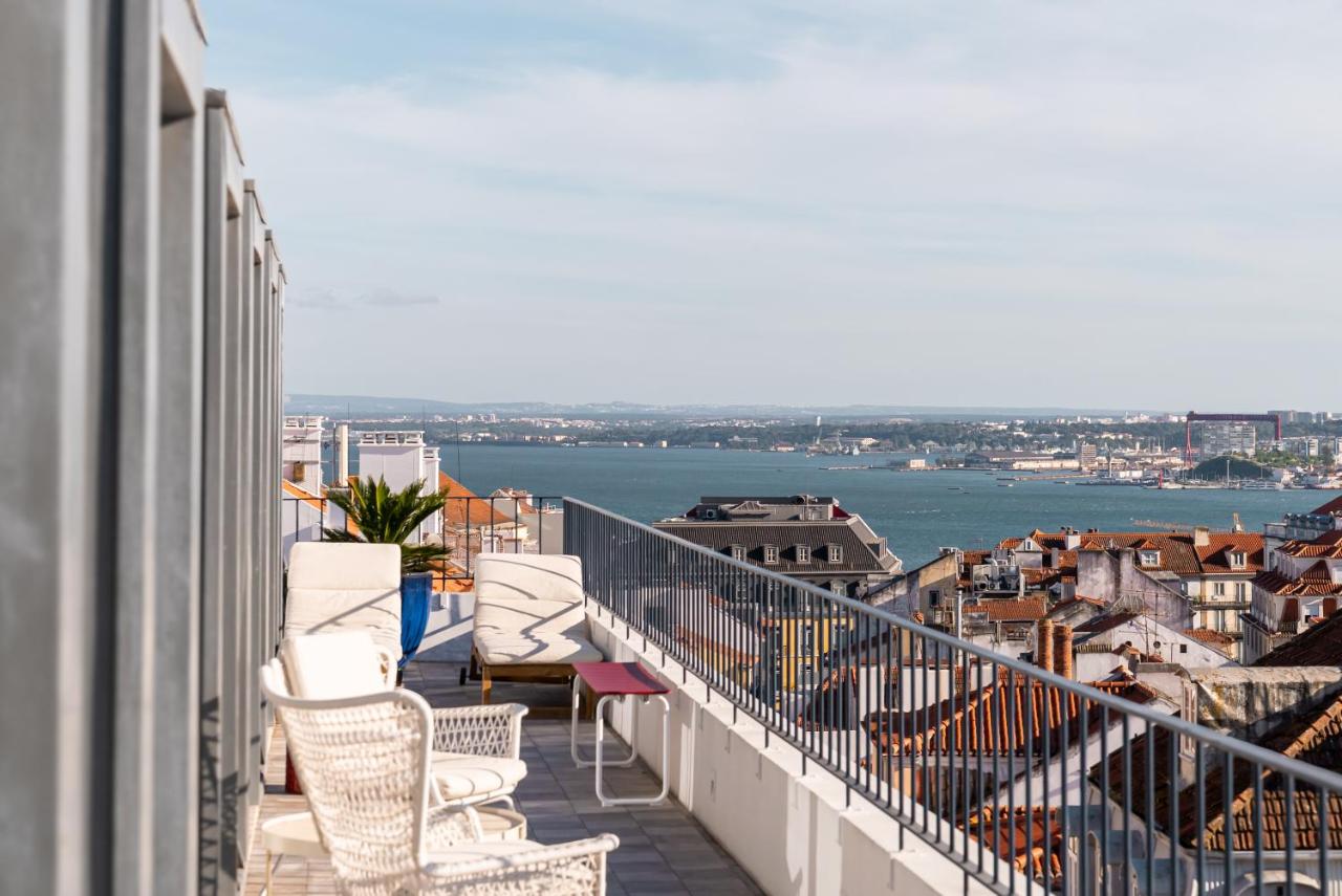 een balkon met stoelen en uitzicht op het water bij Almaria - Ex Libris Apartments | Chiado in Lissabon